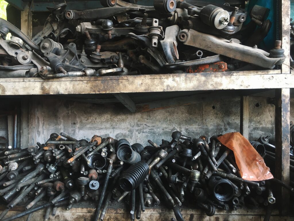 Garage shelf with old broken parts of the control arm, bushing, suspension